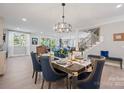 Elegant dining area features stylish seating, modern chandelier, and stairs in the background at 685 Knollcrest Ne Dr, Concord, NC 28025