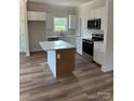Bright kitchen with white cabinets, stainless steel appliances, and a center island with marble top at 7426 Hambright Rd, Huntersville, NC 28078
