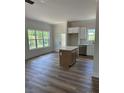 Open living space with an island bar with view into the kitchen, hardwood floors and ample natural light at 7426 Hambright Rd, Huntersville, NC 28078