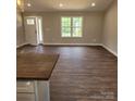Bright, open living area featuring wood-look floors, a large window, and a front door that lets in natural light at 8222 Madison Ln, Hickory, NC 28602