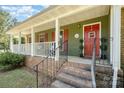 Charming home exterior showcasing a covered front porch, red door, and well-maintained landscaping at 8544 Houston Ridge Rd, Charlotte, NC 28277