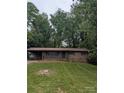 Charming brick home with a covered carport, lush lawn and mature trees, offering a serene setting at 1002 Hemlock Dr, Shelby, NC 28150