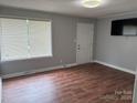 A well-lit living room featuring new vinyl floors and neutral gray paint at 1101 Mona Dr, Charlotte, NC 28206