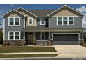 Charming two-story home with a covered front porch and a two-car garage, complete with a landscaped yard at 1119 Bellshill Dv, Indian Trail, NC 28079