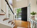 Bright foyer with hardwood floors, staircase, and view to the front yard through an open door at 12632 Landing Green Dr, Charlotte, NC 28277
