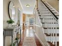 Inviting hallway featuring hardwood floors, staircase, and a view of the dining area and kitchen at 12632 Landing Green Dr, Charlotte, NC 28277