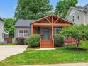 Charming single-story house with a gabled porch, a landscaped lawn, and a concrete driveway at 1425 Downs Ave, Charlotte, NC 28205