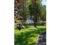Scenic backyard view with a lake and mature trees, providing a private and serene atmosphere at 143 Jeremy Point Pl, Mooresville, NC 28117