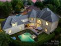 Backyard aerial view featuring a pool, a hot tub, manicured green lawn, and an outdoor living space at 15038 Jockeys Ridge Dr, Charlotte, NC 28277