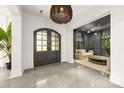 Modern entryway featuring a stylish light fixture, concrete floors, and an arched glass door leading to a living room at 15038 Jockeys Ridge Dr, Charlotte, NC 28277