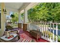 Inviting front porch with comfortable wicker seating and views of a lush, tree-lined street at 17130 Bridgeton Ln, Huntersville, NC 28078