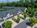 Aerial view of townhomes with manicured lawns, mature trees, and Charlotte city skyline in the background at 1769 Evergreen Dr, Charlotte, NC 28208