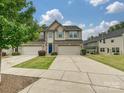 Inviting townhome featuring a two-car garage, blue front door, and well-kept lawn in a residential community at 1769 Evergreen Dr, Charlotte, NC 28208
