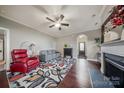 Comfortable living room featuring neutral walls, hardwood flooring, a ceiling fan, and a cozy fireplace at 204 Aztec Cir, Mooresville, NC 28117