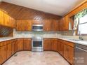 Well-maintained kitchen with stainless steel appliances, wood cabinets, and tiled backsplash at 2222 Hearthstone Dr, Gastonia, NC 28056
