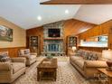 Cozy living room featuring a stone fireplace, wood paneling, and comfortable seating at 2222 Hearthstone Dr, Gastonia, NC 28056