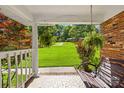 Inviting porch view showcasing a swing, mosaic tile flooring, and lush landscaping at 245 Kingsway Cir, Charlotte, NC 28214