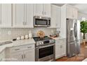 Bright kitchen featuring stainless steel appliances, white cabinets, and quartz countertops at 3009 Loso Ter # 58, Charlotte, NC 28217