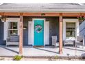 Inviting front porch featuring comfortable seating and a vibrant turquoise door with decorative wreath at 310 Patterson Ave, Mooresville, NC 28115