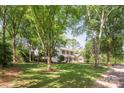 This charming two-story home is surrounded by mature trees and a lush green lawn at 3101 Willowbrae Rd, Charlotte, NC 28226