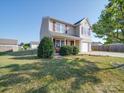 Inviting two-story home with a lush green lawn and attached garage, set under a clear blue sky at 417 Homestead Ln, Albemarle, NC 28001