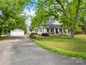 This single Gathering house has a covered front porch with stone pillars, a large driveway, and detached garage at 4960 York Hwy, Rock Hill, SC 29732