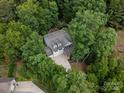 Aerial view of a charming two-story home with a three-car garage nestled in a lush, green, wooded area at 5308 Lambert Ct, Waxhaw, NC 28173