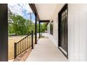 A covered front porch features black railings and plenty of space to sit and relax at 605 Stirewalt Rd, China Grove, NC 28023