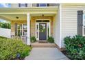 Inviting front porch featuring classic brick accents, a cozy seating area, and manicured landscaping at 6314 Bluffton Ln, Midland, NC 28107