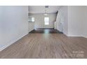 Open-concept living space with wood floors, neutral walls, and an open staircase at 6717 Ware Rd, Charlotte, NC 28212