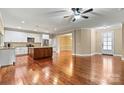 Open living space features a central island, stainless steel appliances, and hardwood floors at 7020 Cedar Ridge Ct, Mount Holly, NC 28120