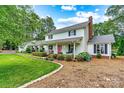 Charming two-story home with a landscaped yard and pink front door at 8218 Bright Water Ln, Denver, NC 28037