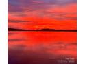 Gorgeous sunrise featuring a beautiful view of the lake with a vibrant red sky and calm water at 8218 Bright Water Ln, Denver, NC 28037