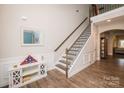 Inviting foyer features hardwood floors, staircase, and decorative mirror, seamlessly blending style and functionality at 9026 Raven Top Dr, Mint Hill, NC 28227