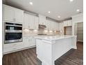 Modern kitchen features white cabinets, stainless steel appliances, and a large center island at 9944 Manor Vista Trl, Kannapolis, NC 28027