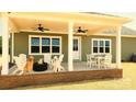 Cozy covered back porch featuring comfortable seating, a fire pit, ceiling fans and views of the backyard at Lot 101 Coppergate Dr, Salisbury, NC 28147