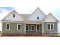 New construction featuring a charming exterior with a mix of brick and vertical siding and a covered porch at Lot 101 Coppergate Dr, Salisbury, NC 28147