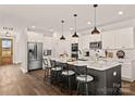 Modern kitchen features a large island with counter seating and stainless steel appliances at Lot 101 Coppergate Dr, Salisbury, NC 28147