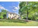 Beautiful white painted brick home with a sprawling green lawn and mature trees in a peaceful setting at 10016 Tealridge Ln, Charlotte, NC 28277