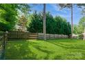 Large backyard featuring a well-maintained lawn and a classic wooden fence at 104 Gallarie Pl, Salisbury, NC 28144