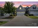 Charming townhome featuring a two-car garage, manicured lawn, and sky at dusk at 1108 Stella Ct, Monroe, NC 28110