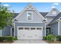 Close-up of a two-car garage with white door and a well-kept lawn at 1108 Stella Ct, Monroe, NC 28110