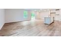 Open-concept living area with expansive windows and sliding glass doors, featuring elegant wood flooring at 126 Dorian Pl, Troutman, NC 28166