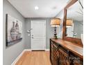 Hallway with wood floors, gray walls, and a wooden console table at 1320 Fillmore Ave # 137, Charlotte, NC 28203