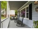 Cozy front porch with rocking chairs and a bench, perfect for enjoying the outdoors at 16612 Grapperhall Dr, Huntersville, NC 28078