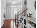 Elegant foyer with hardwood floors, a staircase with wrought iron railings, and plenty of natural light at 16831 Alydar Commons Ln, Charlotte, NC 28278