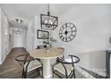 A cozy dining area with a round table, stylish chairs, a modern light fixture, and a striking wall clock at 177 Briana Marie Way, Indian Trail, NC 28079