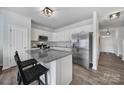 A modern kitchen with granite countertops, stainless steel appliances, and a breakfast bar with seating for two at 177 Briana Marie Way, Indian Trail, NC 28079