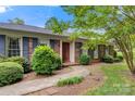 Brick home with blue shutters, mature bushes, and a walkway to the front door at 1940 12Th Ne St, Hickory, NC 28601