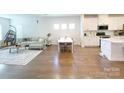 Open-concept living area with hardwood floors, white walls, and plenty of natural light at 2019 Tears Ln, Charlotte, NC 28217